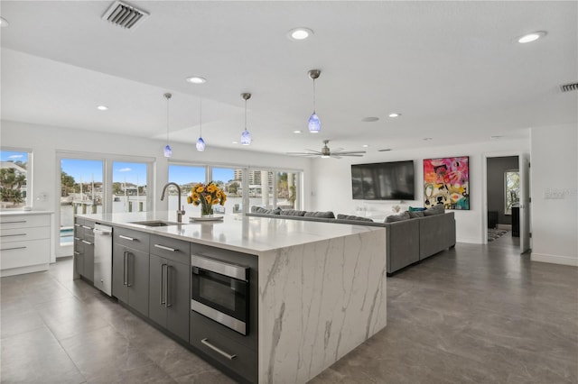 kitchen featuring plenty of natural light, sink, a kitchen island with sink, and appliances with stainless steel finishes