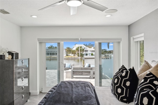 bedroom with access to outside, multiple windows, a water view, and ceiling fan