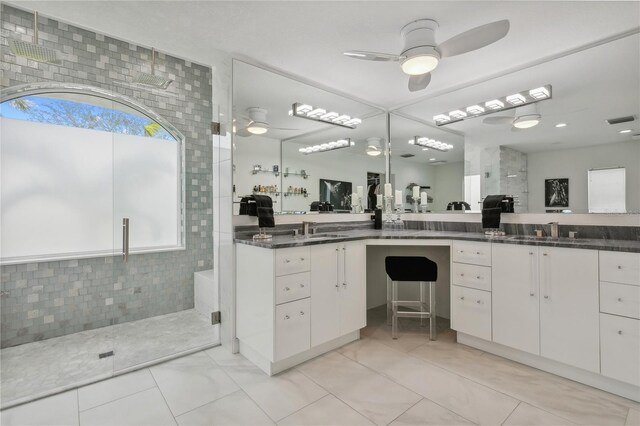 bathroom featuring tiled shower, tile patterned floors, tile walls, vanity, and ceiling fan