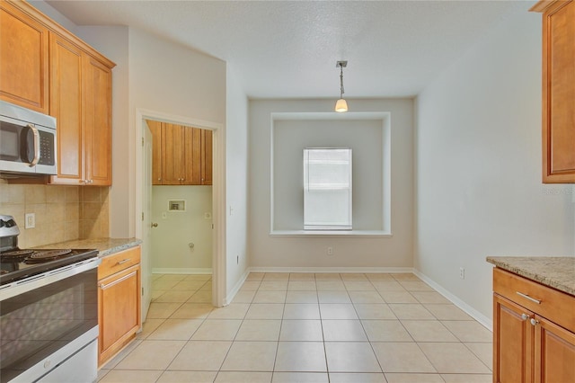 7110 Moss Ledge Run, Land O Lakes, FL 34637 - kitchen featuring tasteful backsplash, light stone countertops, light tile patterned floors, decorative light fixtures, and appliances with stainless steel finishes