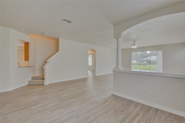 7110 Moss Ledge Run, Land O Lakes, FL 34637 - unfurnished living room with ornate columns, visible vents, light wood finished floors, and arched walkways
