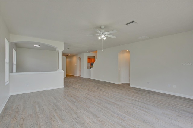 7110 Moss Ledge Run, Land O Lakes, FL 34637 - unfurnished room featuring decorative columns, light wood-type flooring, a ceiling fan, visible vents, and arched walkways