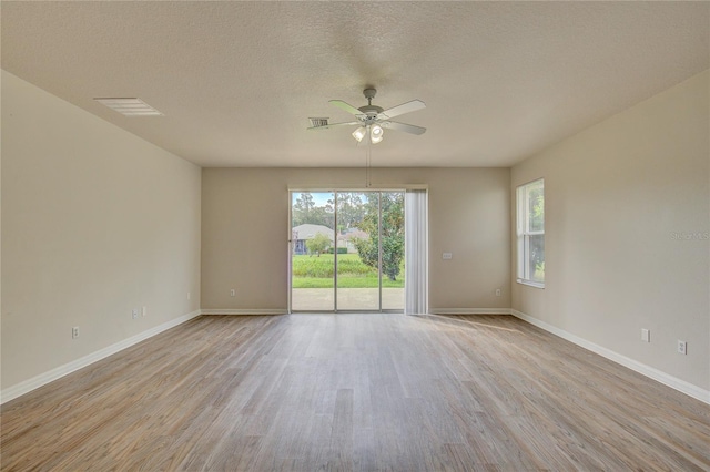 7110 Moss Ledge Run, Land O Lakes, FL 34637 - unfurnished room featuring ceiling fan, baseboards, light wood-style flooring, and a healthy amount of sunlight
