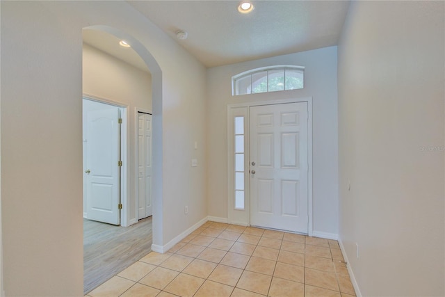 7110 Moss Ledge Run, Land O Lakes, FL 34637 - entrance foyer featuring baseboards, light tile patterned floors, arched walkways, and recessed lighting