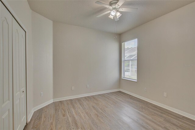 7110 Moss Ledge Run, Land O Lakes, FL 34637 - unfurnished bedroom with baseboards, ceiling fan, a closet, and light wood-style flooring