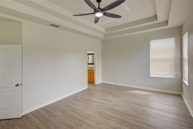 7110 Moss Ledge Run, Land O Lakes, FL 34637 - spare room featuring ceiling fan, a tray ceiling, light wood-type flooring, visible vents, and baseboards
