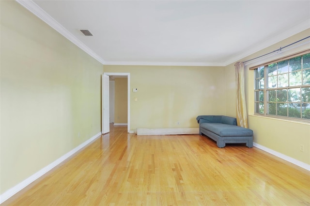 unfurnished room with ornamental molding and light wood-type flooring