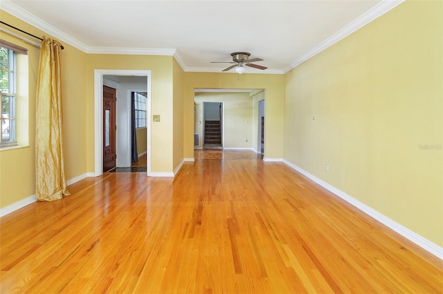 empty room with crown molding, light wood-type flooring, and ceiling fan