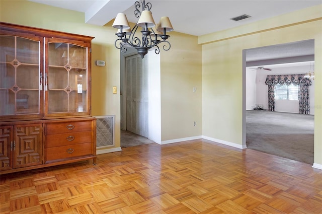 unfurnished dining area with light parquet flooring and ceiling fan with notable chandelier