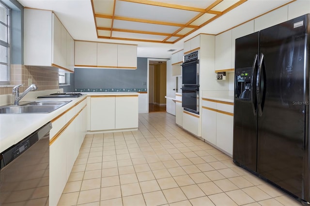 kitchen featuring white cabinetry, backsplash, black appliances, and sink