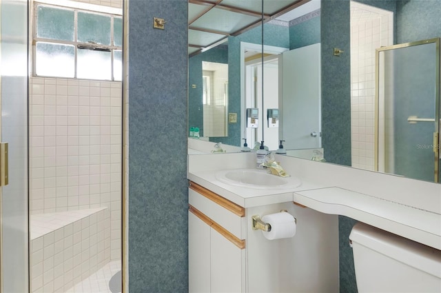 bathroom with toilet, an enclosed shower, and vanity