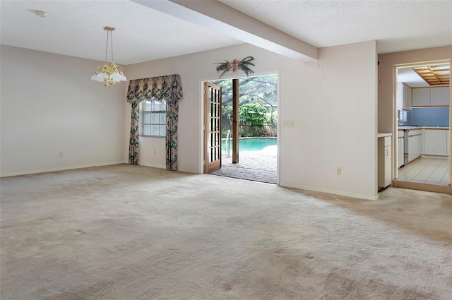 unfurnished room with a textured ceiling and light colored carpet