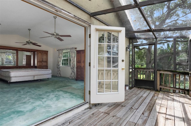 unfurnished sunroom featuring lofted ceiling with beams, plenty of natural light, and ceiling fan