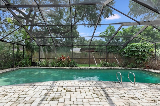 view of pool with a patio and glass enclosure