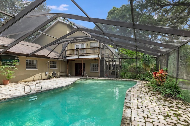 view of swimming pool featuring a patio area and glass enclosure