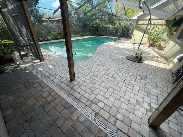 view of swimming pool featuring a patio and a lanai