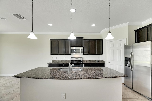 kitchen featuring an island with sink, pendant lighting, and stainless steel appliances