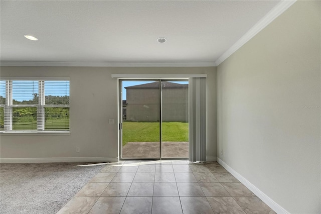 spare room featuring a healthy amount of sunlight, ornamental molding, and light colored carpet