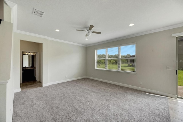 empty room with ceiling fan, light carpet, and ornamental molding