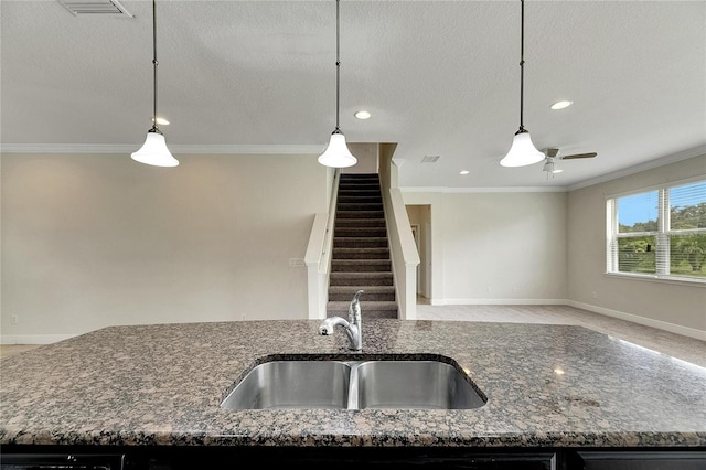 kitchen with pendant lighting, ceiling fan, crown molding, and sink