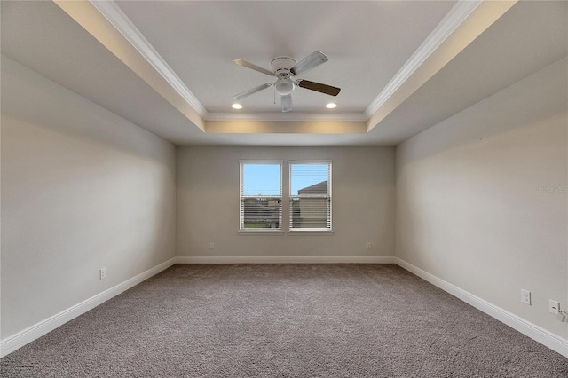 carpeted spare room with ceiling fan, a tray ceiling, and ornamental molding