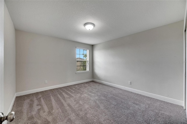 carpeted empty room with a textured ceiling