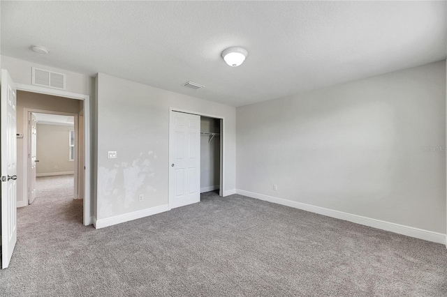 unfurnished bedroom featuring carpet floors, a textured ceiling, and a closet