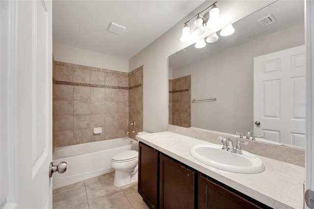 full bathroom with vanity, a textured ceiling, tile patterned flooring, toilet, and tiled shower / bath