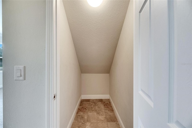 spacious closet featuring vaulted ceiling and light tile patterned floors