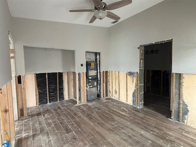 empty room with ceiling fan, dark hardwood / wood-style flooring, and vaulted ceiling