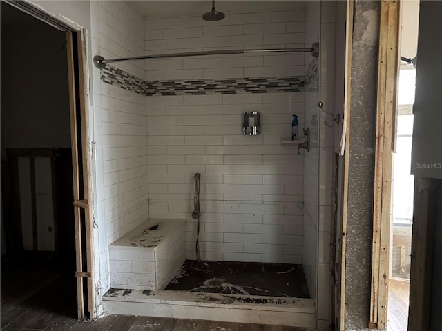 bathroom with hardwood / wood-style floors and tiled shower