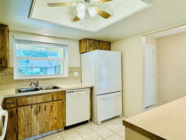 kitchen with backsplash, ceiling fan, sink, and white appliances