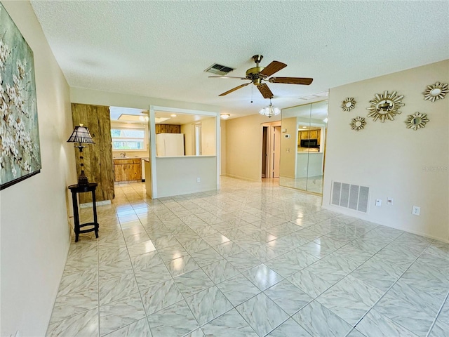 unfurnished room featuring a textured ceiling and ceiling fan