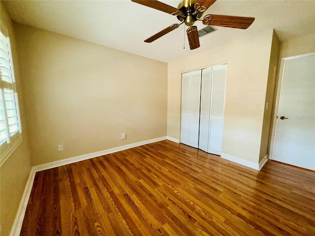 unfurnished bedroom with wood-type flooring, ceiling fan, and a closet