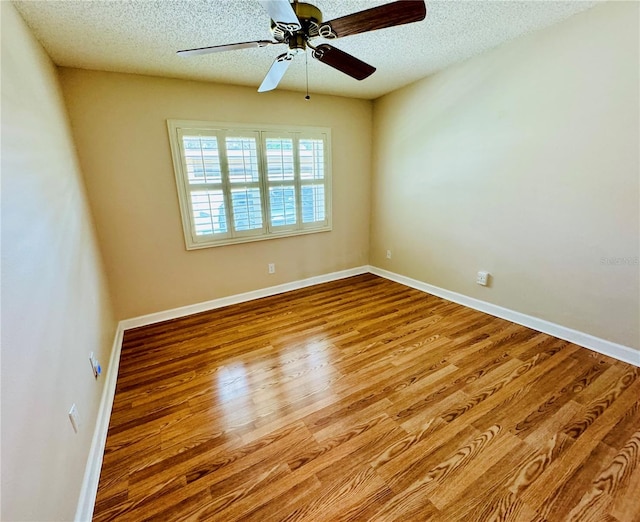 spare room featuring light wood-type flooring, ceiling fan, and a textured ceiling