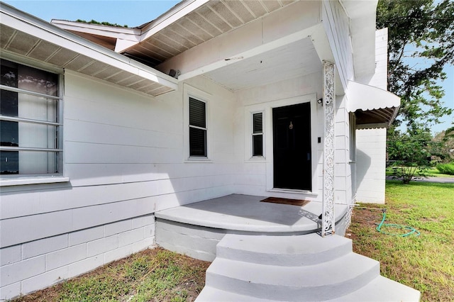 view of exterior entry featuring a yard