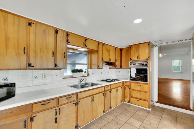 kitchen featuring black appliances, light tile patterned flooring, sink, and plenty of natural light