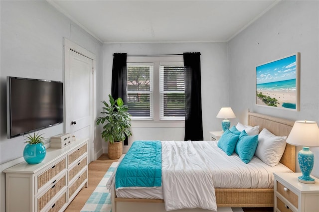 bedroom with light hardwood / wood-style floors and crown molding