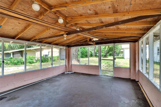 unfurnished sunroom featuring vaulted ceiling with beams