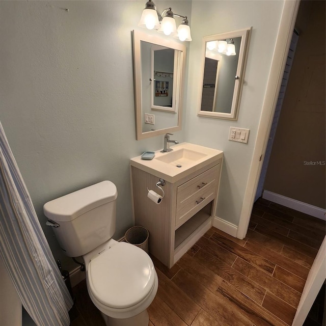 bathroom with wood-type flooring, vanity, and toilet