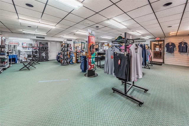 exercise room featuring a paneled ceiling and carpet flooring