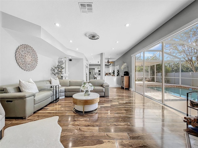 living room featuring ceiling fan and a textured ceiling