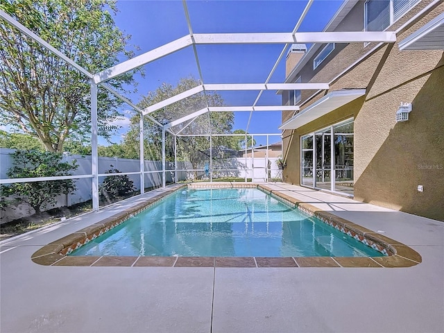 view of swimming pool featuring a patio area and a lanai