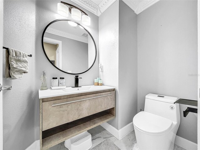 bathroom featuring vanity, toilet, and ornamental molding