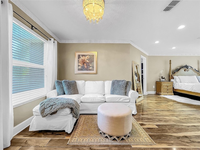 bedroom with multiple windows, crown molding, and a notable chandelier