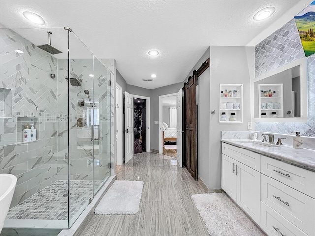 bathroom featuring vanity, a shower with door, and a textured ceiling