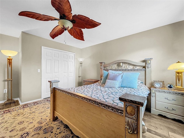 bedroom with a closet, light hardwood / wood-style floors, and ceiling fan