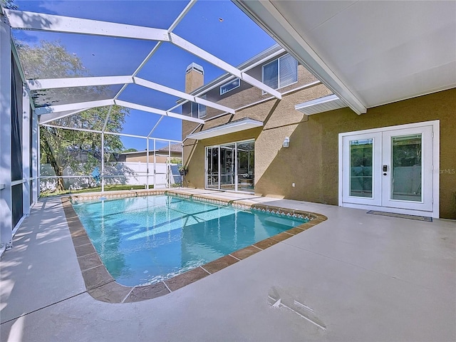 view of pool with french doors, a lanai, and a patio area