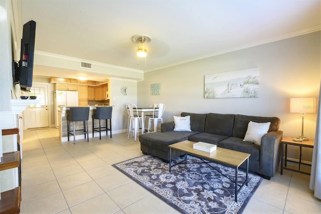 living room with ceiling fan, crown molding, and light tile patterned floors