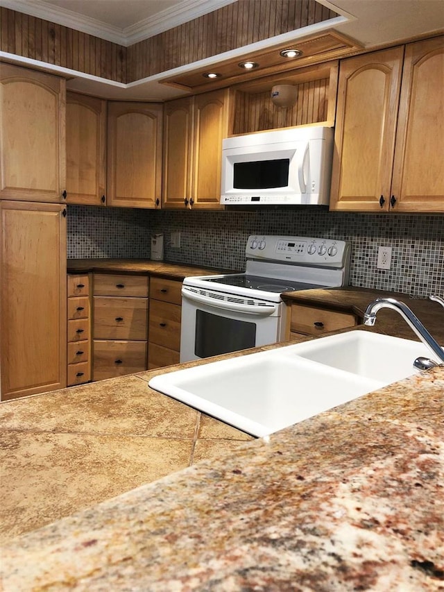 kitchen featuring backsplash, crown molding, sink, and white appliances